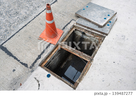 Open manhole drain creates street sewer hazard evoking cautious fear 139487277