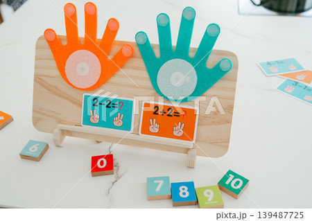 Wooden math board with colorful counters and numbers. Designed for interactive learning and developing counting skills in children. Wooden math board with colorful counters and numbers. Designed for interactive learning and developing counting skills in children. 139487725