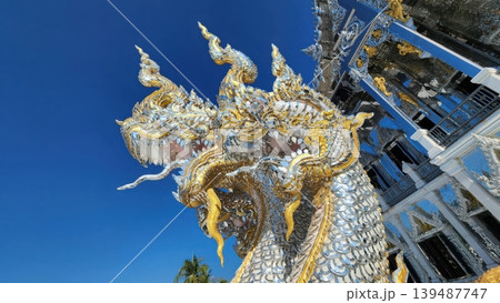 The Glimmering Guardian Majestic Silver and Gold Naga Under a Deep Blue Sky 139487747