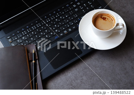パソコンとコーヒー - 淹れたてのコーヒーを飲みながら、ノートパソコンでデスクワーク中のイメージ パソコンとコーヒー - 淹れたてのコーヒーを飲みながら、ノートパソコンでデスクワーク中のイメージ 139488522