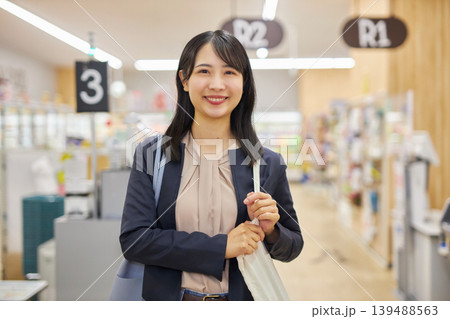 セルフレジで清算を済ませてエコバッグを肩に描ける若い女性 139488563