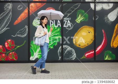 日傘をさしてスーパーマーケットへ行く若い女性 日傘をさしてスーパーマーケットへ行く若い女性 139488682