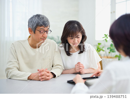 夫婦にタブレットで説明をする営業の女性 夫婦にタブレットで説明をする営業の女性 139488751