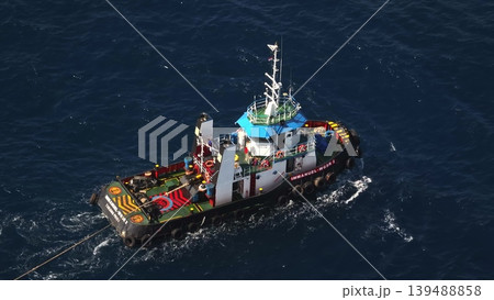 2023.06.10 - Indonesia, Bali: Tugboat Immanuel WGSR 2 navigates a calm ocean, engaged in a towing operation, demonstrating essential maritime logistics and assistance at sea from an aerial perspective 2023.06.10 - Indonesia, Bali: Tugboat Immanuel WGSR 2 navigates a calm ocean, engaged in a towing operation, demonstrating essential maritime logistics and assistance at sea from an aerial perspective 139488858