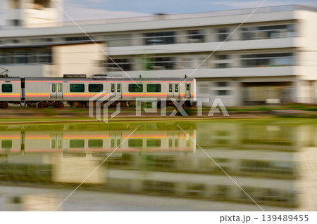 朝日に照らされた田園風景とローカル列車のリフレクション 朝日に照らされた田園風景とローカル列車のリフレクション 139489455