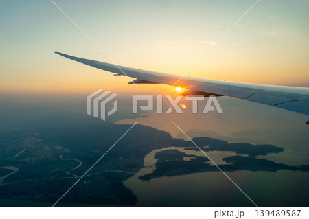 Airplane wing above Osaka coast during sunset descent flight Airplane wing above Osaka coast during sunset descent flight 139489587