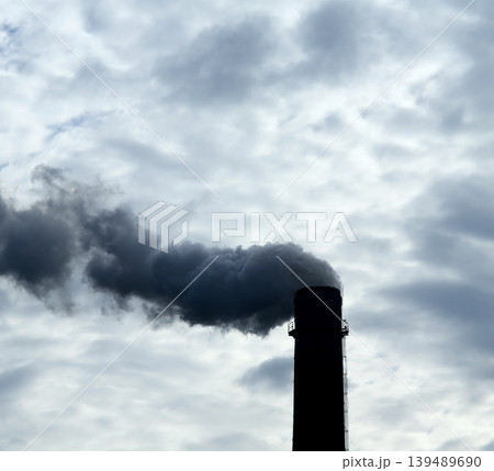 Clouds of dark smoke from power plant smokestack contaminates the air over cloudy sky Clouds of dark smoke from power plant smokestack contaminates the air over cloudy sky 139489690