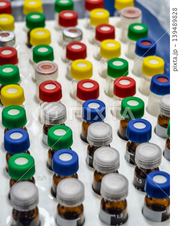 Various vials with colored caps arranged on a laboratory table in a research setting during the daytime 139489828