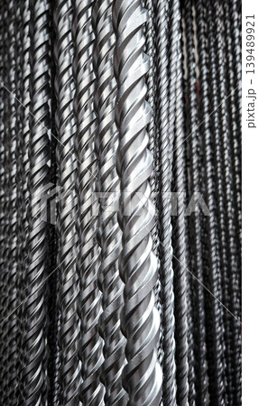 Long steel drill bits are lined up in a row, showing the spiral flutes. These tools are used for metalworking and precision engineering in various manufacturing processes. Long steel drill bits are lined up in a row, showing the spiral flutes. These tools are used for metalworking and precision engineering in various manufacturing processes. 139489921