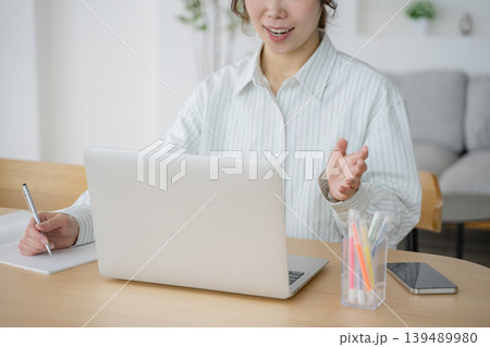 パソコンの画面に向かって話す女性 パソコンの画面に向かって話す女性 139489980