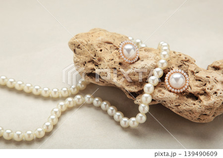 Beautiful pearl earring and necklace on stone on light background Beautiful pearl earring and necklace on stone on light background 139490609