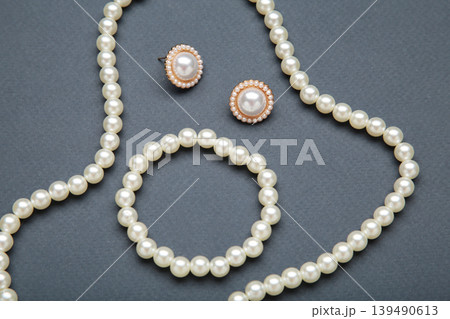 Beautiful pearl bracelet, earring, and necklace on dark blue background 139490613
