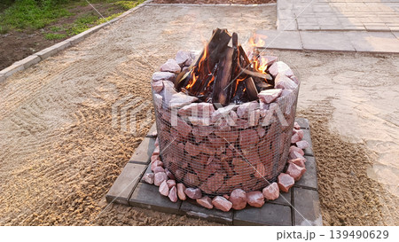Stone fire pit in the backyard. Space for text Stone fire pit in the backyard. Space for text 139490629