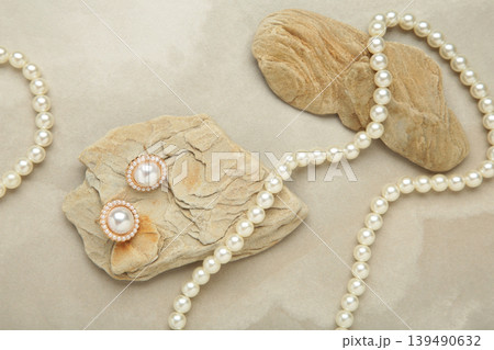Beautiful pearl earring and necklace on stone on light background Beautiful pearl earring and necklace on stone on light background 139490632