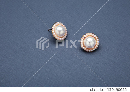 Stylish pearl earrings on blue background. Top view 139490633