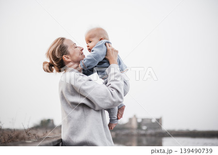 Tender woman caressing her little baby boy infant child outdoors on autumn trip to Secovlje salinas landscape park, Slovenia. Mother's unconditional love for her child Tender woman caressing her little baby boy infant child outdoors on autumn trip to Secovlje salinas landscape park, Slovenia. Mother's unconditional love for her child 139490739