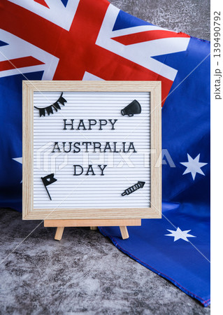 Letterboard with text HAPPY AUSTRALIA DAY next to the Aussie flag festive greeting cards. Australian flag. Concept of joy and national spirit 139490792