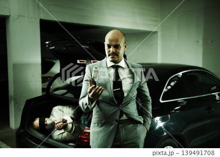 Man in trunk of car, kidnapping and thief with money, danger and violence in basement garage. Crime, human trafficking and scared person tied with rope parking lot with gangster, ransom and terror. Man in trunk of car, kidnapping and thief with money, danger and violence in basement garage. Crime, human trafficking and scared person tied with rope parking lot with gangster, ransom and terror. 139491708
