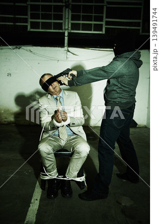 Man, abduction and criminal with gun and phone call for money, ransom negotiation and terror, crime or danger. Gangster, scared person or hostage with fear, intel and talking on a mobile in basement Man, abduction and criminal with gun and phone call for money, ransom negotiation and terror, crime or danger. Gangster, scared person or hostage with fear, intel and talking on a mobile in basement 139491744