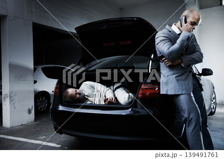 Man, kidnap and parking lot with phone call for ransom, negotiation and criminal with hostage, crime and danger. Gangster, mafia and scared person for gun, tied up and fear for life in debt or scam 139491761