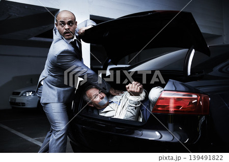 Man in car, kidnapping and mafia with fear, danger and violence in basement garage. Crime, human trafficking and scared person tied with rope in trunk in parking lot with gangster, ransom and terror. 139491822