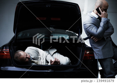Phone call, car and man with victim in trunk for negotiation, kidnapping danger and ransom. Mafia, gangster criminal and business person in boot for money, debt and payment in parking lot with gun Phone call, car and man with victim in trunk for negotiation, kidnapping danger and ransom. Mafia, gangster criminal and business person in boot for money, debt and payment in parking lot with gun 139491879