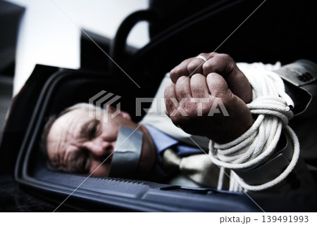 Car boot, kidnap and portrait of sad business man with tape, rope or crime danger in parking lot. Fear, stress and face of male victim in vehicle trunk with anxiety, horror or panic, scared or ransom Car boot, kidnap and portrait of sad business man with tape, rope or crime danger in parking lot. Fear, stress and face of male victim in vehicle trunk with anxiety, horror or panic, scared or ransom 139491993