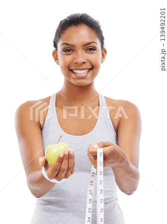 Woman, portrait and lose weight with a measuring tape and apple in white background or studio. Happy, model and healthy food for results in fitness, wellness and diet with nutrition and fruit Woman, portrait and lose weight with a measuring tape and apple in white background or studio. Happy, model and healthy food for results in fitness, wellness and diet with nutrition and fruit 139492201