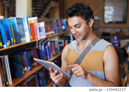 Research, tablet or happy man in library at university, college or school campus for education. Bookshelf, elearning or male student with scholarship studying knowledge, online course or information Research, tablet or happy man in library at university, college or school campus for education. Bookshelf, elearning or male student with scholarship studying knowledge, online course or information 139492237