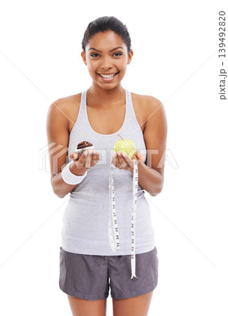 Woman, portrait and cupcake or apple choice in studio or healthy decision, diet balance or white background. Female person, dessert and fruit or tape measure as weight loss, mockup space or nutrition 139492820