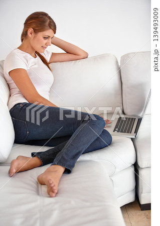 Woman, laptop and relax in home on sofa to watch movies, digital news subscription and streaming multimedia. Computer, online shopping and search blog post, social network and download in living room 139493009
