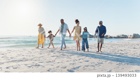 Holding hands, walking and big family at the beach on vacation, adventure or holiday together. Love, travel and children with parents and grandparents on the sand by the ocean or sea on weekend trip. Holding hands, walking and big family at the beach on vacation, adventure or holiday together. Love, travel and children with parents and grandparents on the sand by the ocean or sea on weekend trip. 139493033