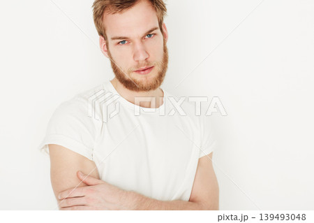 Man, portrait and confident or fashion in studio with casual style, trendy outfit and calm expression. Person, face and relaxing, t-shirt and satisfaction with peace and pride on white background 139493048