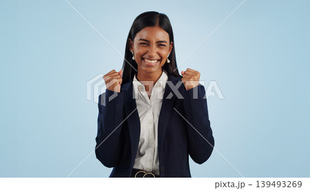 Winner, excited or happy woman in celebration for a business deal isolated on blue background. Wow, goals or proud Indian lady with smile, victory success or reward in entrepreneurship or studio 139493269