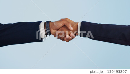 Business people, handshake and meeting for partnership, deal or agreement against a blue studio background. Closeup of employees shaking hands for b2b, introduction or thank you on mockup space Business people, handshake and meeting for partnership, deal or agreement against a blue studio background. Closeup of employees shaking hands for b2b, introduction or thank you on mockup space 139493297