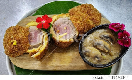Crispy Fried Chicken Cordon Bleu with Ham Cheese Filling and Mushroom Gravy on Wooden Plate 139493365