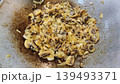 Sauteed sliced mushrooms and onions cooking in a metal wok pan for delicious homemade meal. 139493371