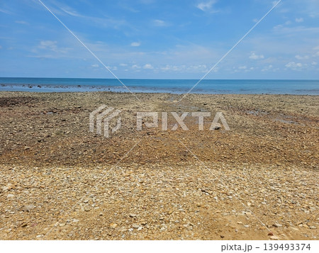 Wide Angle View of Pebble Stone Beach and Calm Blue Sea Under Clear Sky 139493374