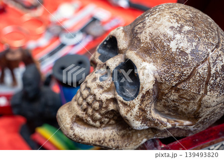 A detailed view of a decorative skull on a table at a flea market in Cairo. Various antiques and crafts are visible in the background. A detailed view of a decorative skull on a table at a flea market in Cairo. Various antiques and crafts are visible in the background. 139493820