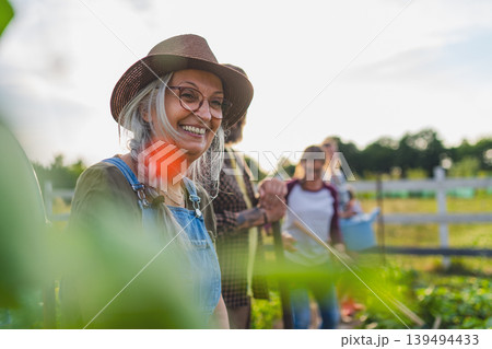Happy farmers or gardeners working outdoors at community farm. Happy farmers or gardeners working outdoors at community farm. 139494433