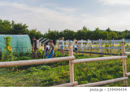 Happy farmers or gardeners working outdoors at community farm. Happy farmers or gardeners working outdoors at community farm. 139494434