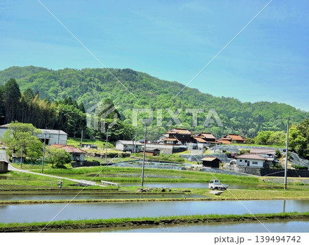 見渡す限りの青空と、田植えを待つ水田が広がる里山 見渡す限りの青空と、田植えを待つ水田が広がる里山 139494742