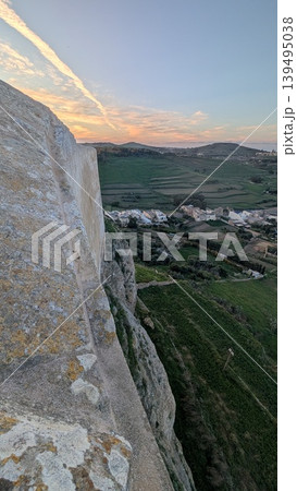 Evening rural landscape taken from the stone wall of a cliff on a hill in Gozo 139495038
