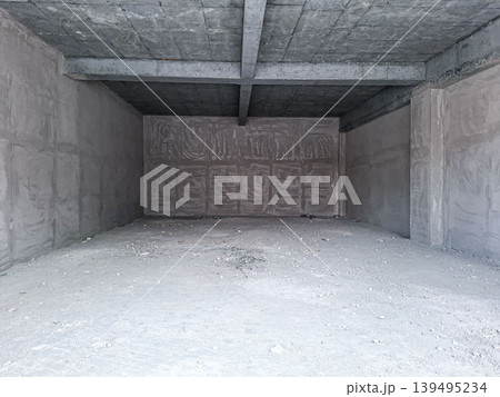 The scene shows an empty concrete room under construction. The walls are raw, and the floor is dusty. This space is ideal for future renovation or real estate ideas. 139495234