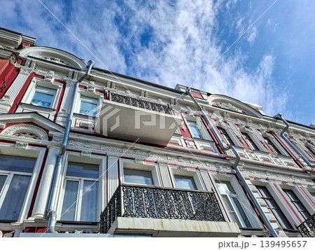 A building in Baroque style is shown from a low angle. The white stuccowork and red facades create a striking view against the blue sky. The design highlights intricate details and balconies. A building in Baroque style is shown from a low angle. The white stuccowork and red facades create a striking view against the blue sky. The design highlights intricate details and balconies. 139495657