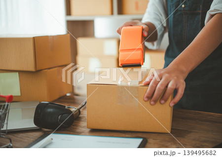 Online small business owner is packing products for customers according to their orders online-Shopping online concept. Online small business owner is packing products for customers according to their orders online-Shopping online concept. 139495682