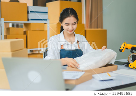 Online small business owners are packing their ordered products that customers order online into a box .concept of online shopping Online small business owners are packing their ordered products that customers order online into a box .concept of online shopping 139495683