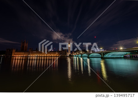 London United Kingdom panoramic night skyline Big Ben the Houses of Parliament and Westminster bridge illuminated clock tower riverside buildings reflection water. London United Kingdom panoramic night skyline Big Ben the Houses of Parliament and Westminster bridge illuminated clock tower riverside buildings reflection water. 139495717