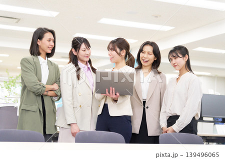 女性社員たちがノートパソコンを囲んで打ち合わせをするオフィス風景 女性社員たちがノートパソコンを囲んで打ち合わせをするオフィス風景 139496065