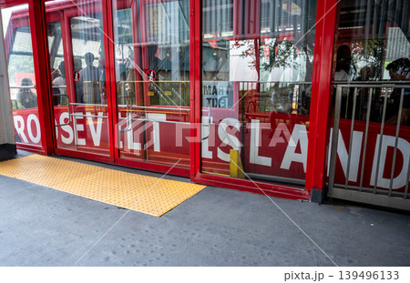 New york, usa august 17,2024. Roosevelt island tram car at station with passengers visible through glass windows, red exterior reading roosevelt island 139496133